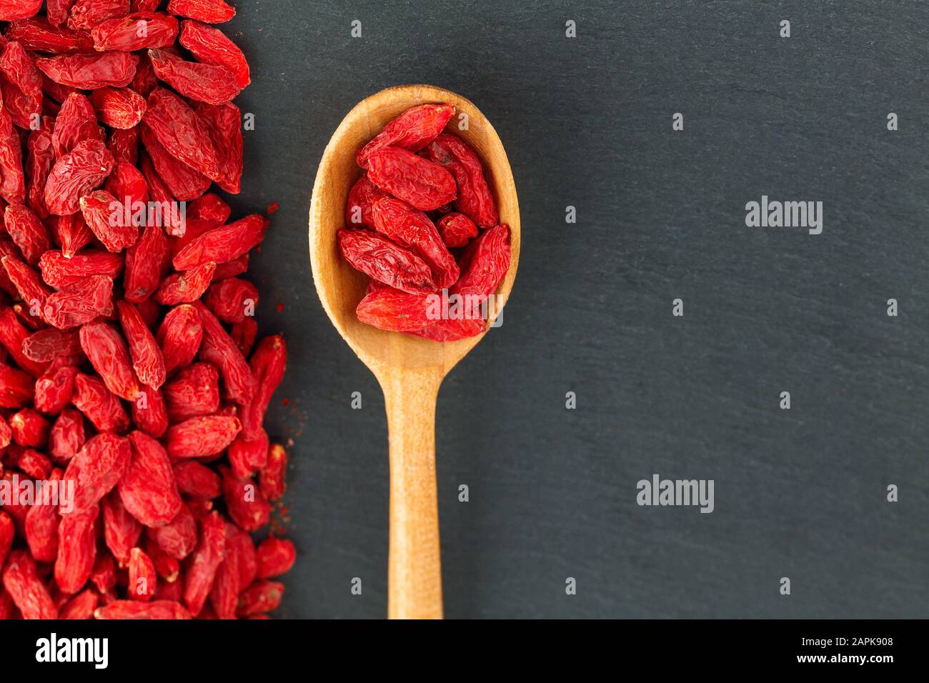 Goji berries. Spoon with organic berry over gray slate background Stock Photo