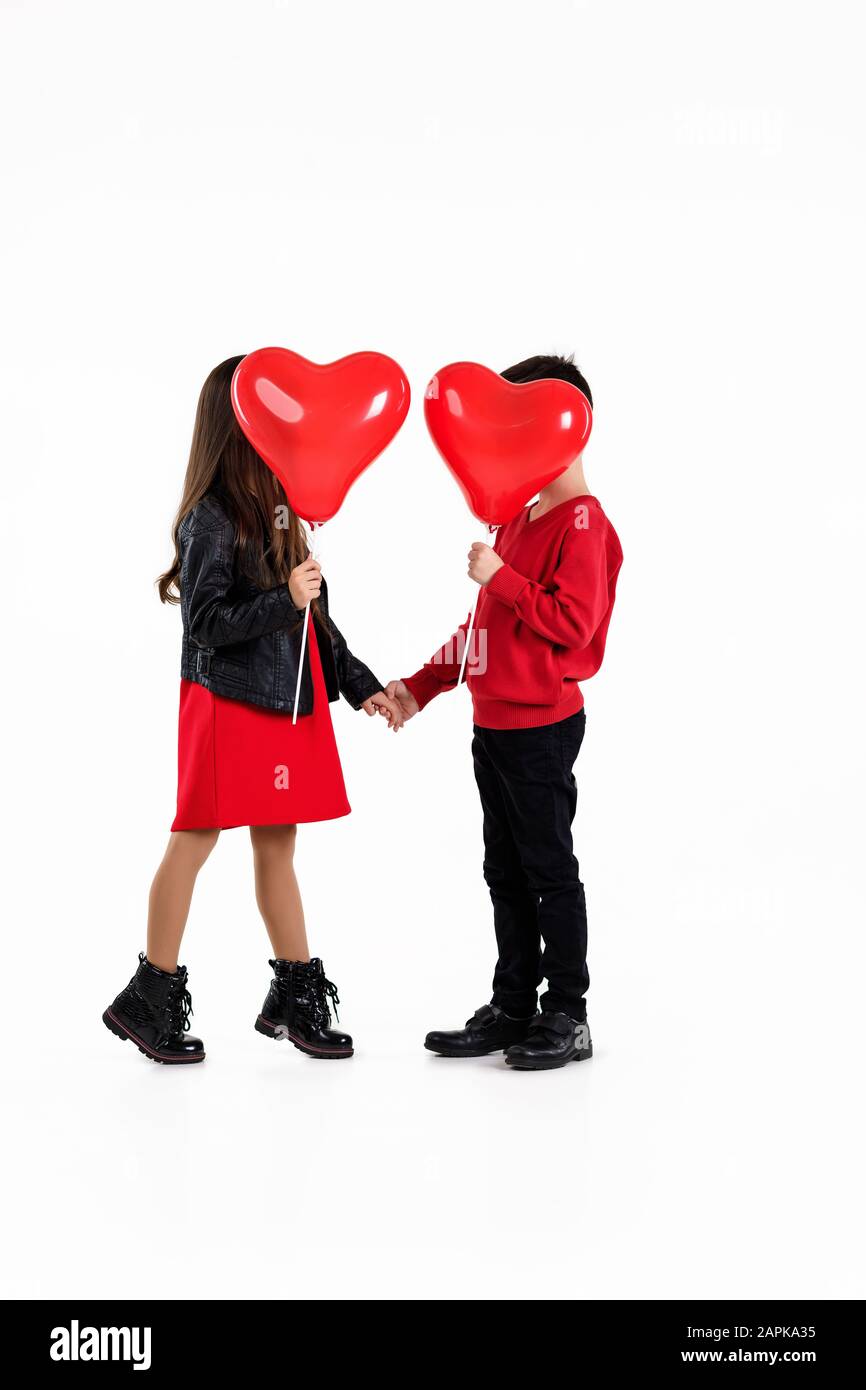 couple child girl and boy holding red heart balloons isolated on white ...