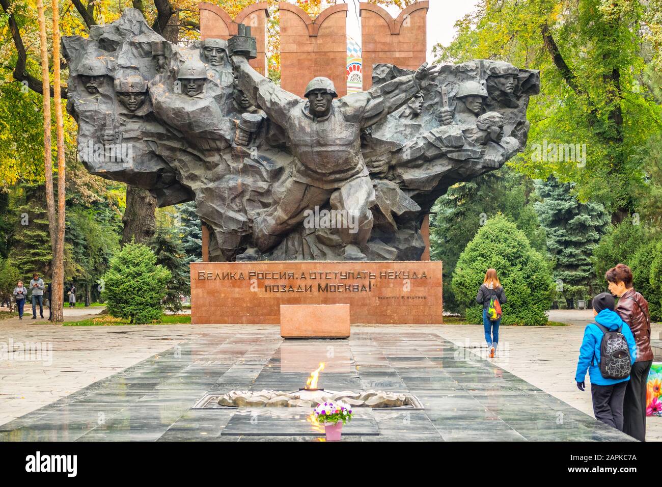People visit the eternal flame at the World War II Monument in Panfilov Park in downtown Almaty Kazakhstan. Stock Photo