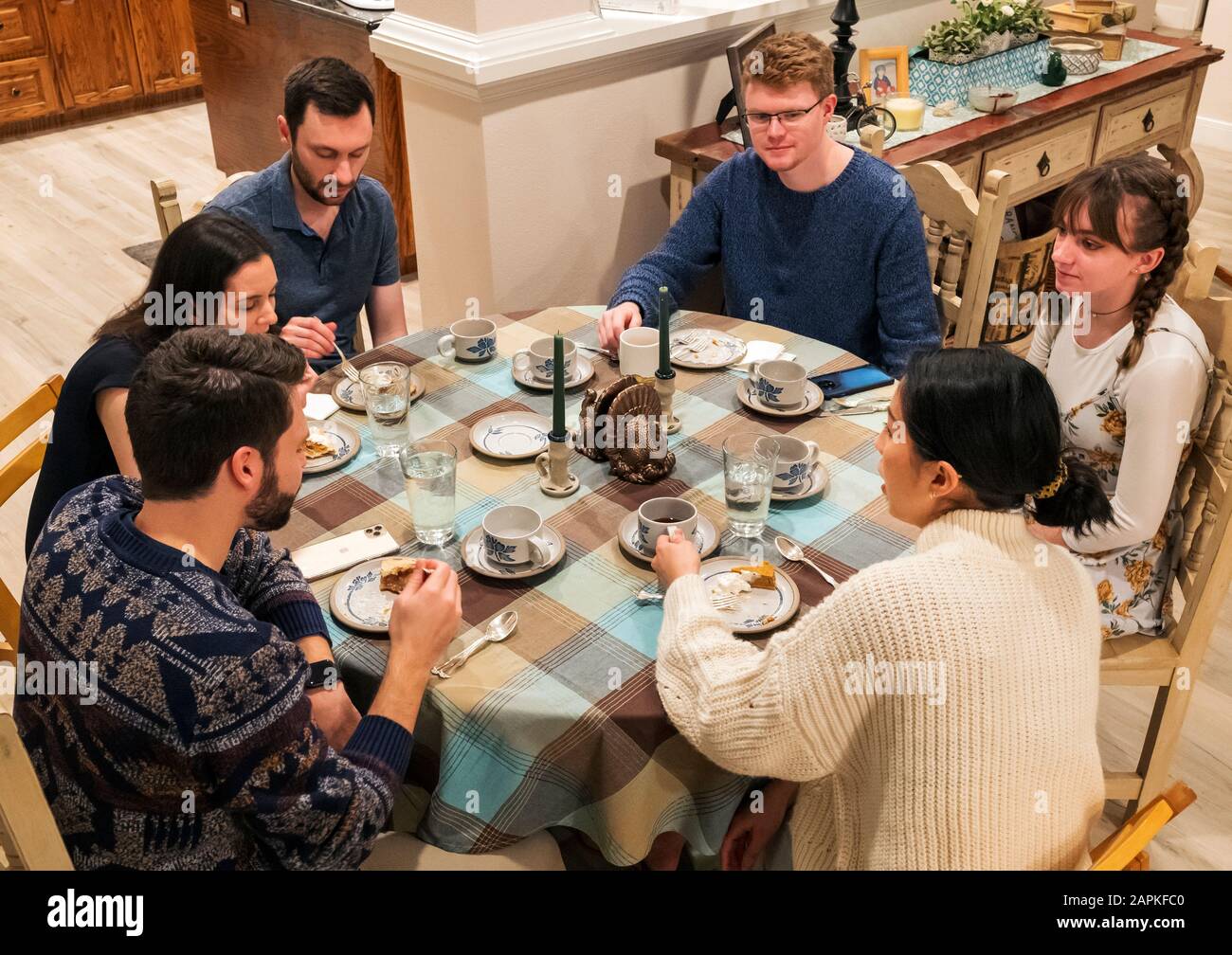 Family seated around Thanksgiving dinner table Stock Photo