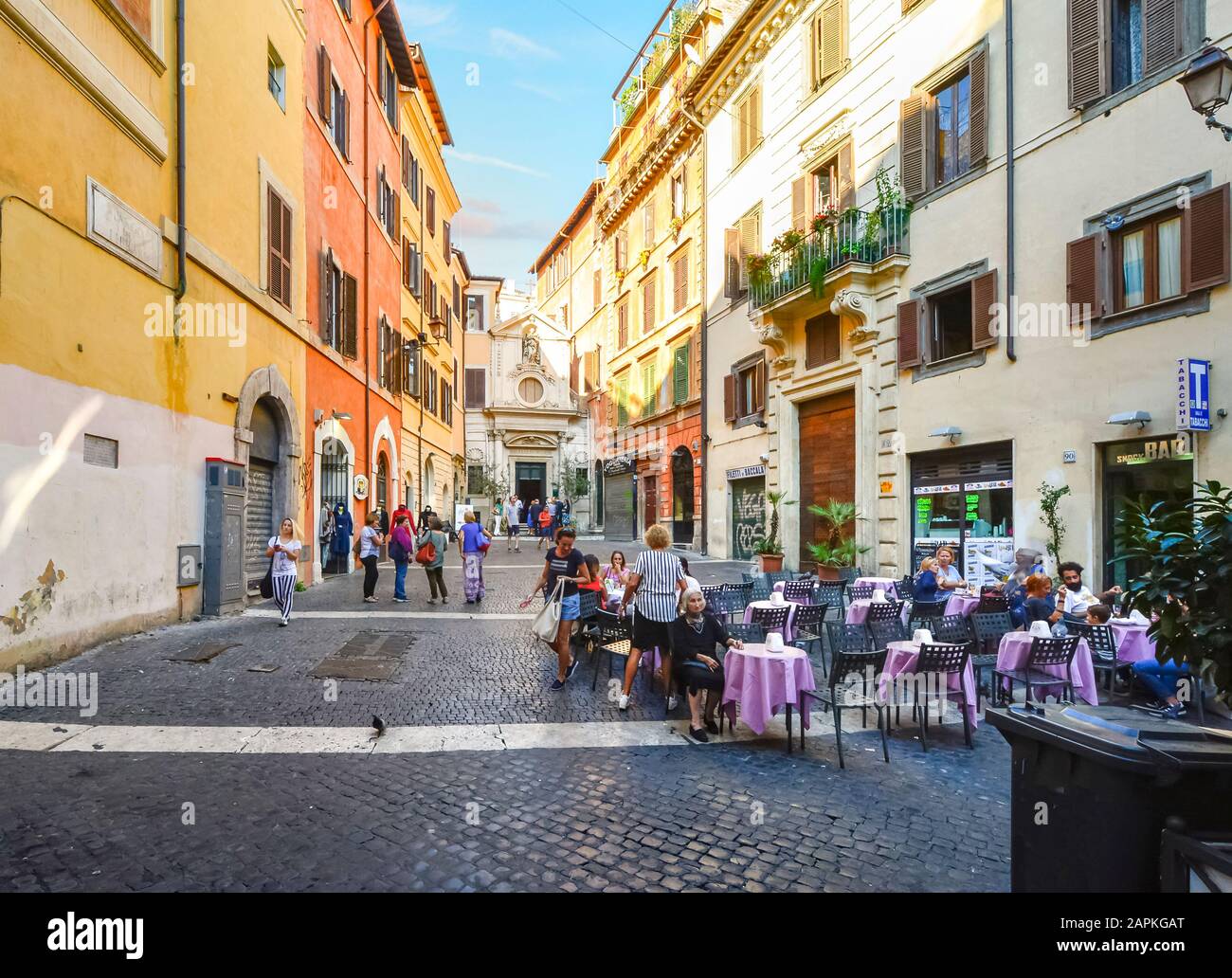 Local Italians including young people and an old woman enjoy a small piazza and cafe in the historic center of Rome, Italy. Stock Photo