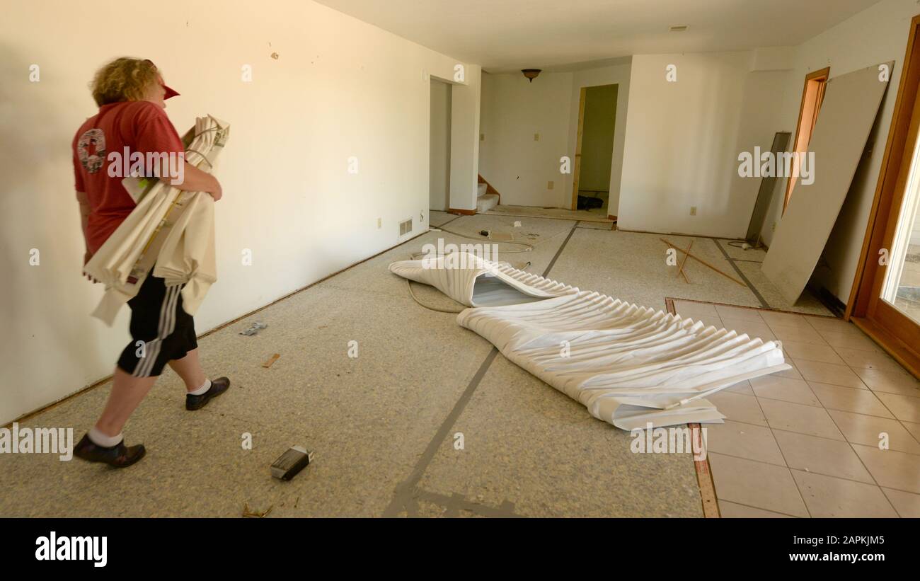 Mount Pleasant, Wisconsin, USA. 23rd June, 2018. Local resident CAROL  ECKHOLM carries window treatments from the recreation room of the family  home in the Village of Mount Pleasant, Wisconsin to their car