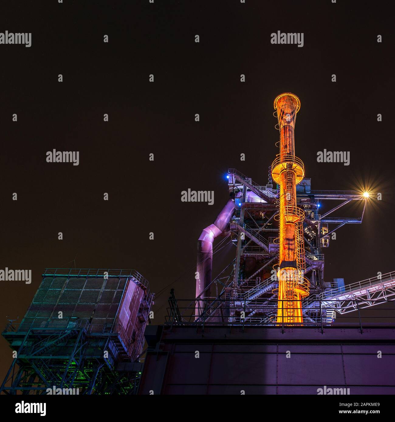 Amazing low angle shot of a building and tower with colorful lights at night Stock Photo