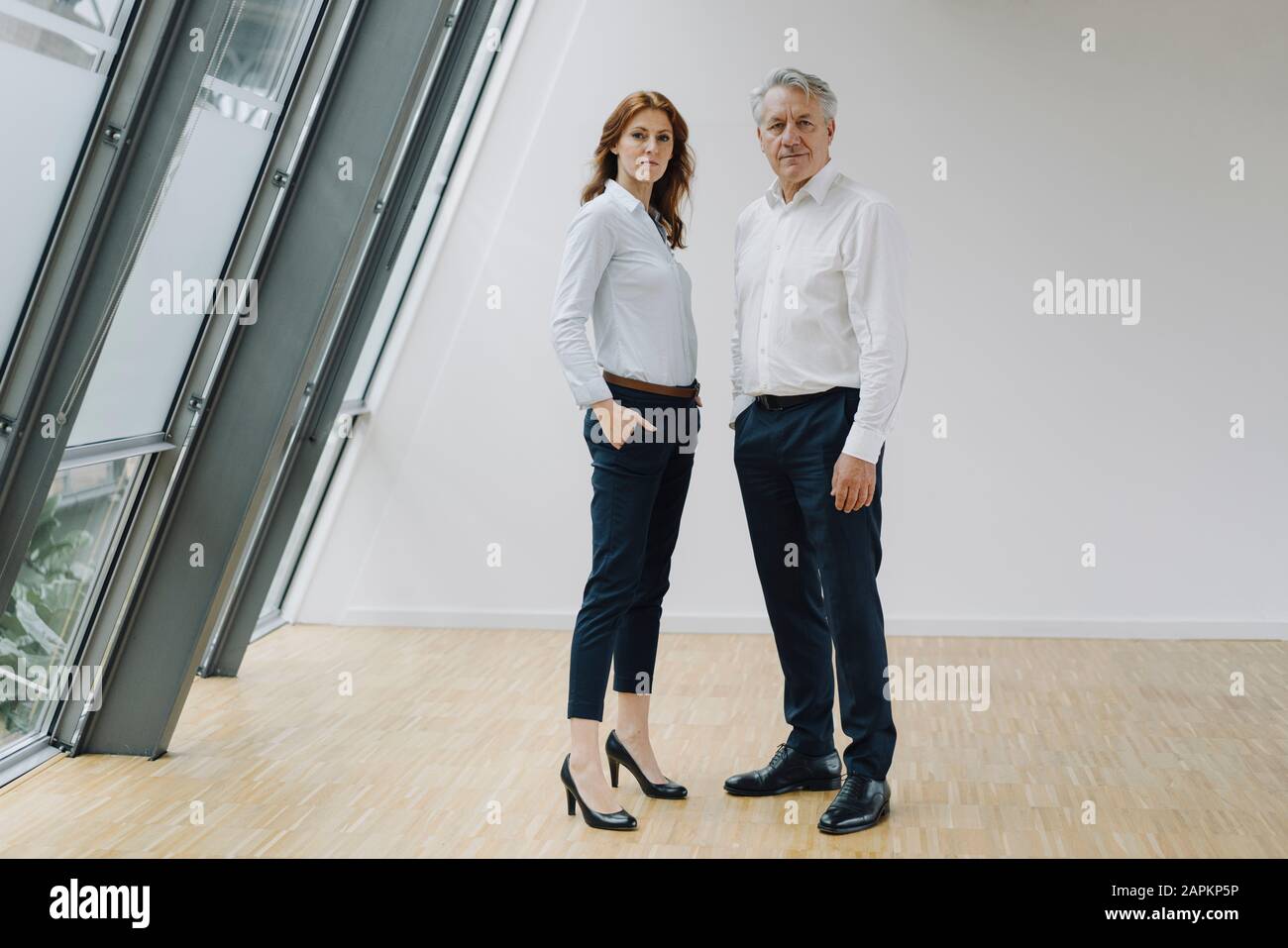 Portrait of confident businessman and businesswoman standing in office Stock Photo