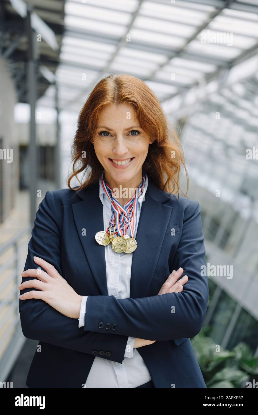 Portait of a smiling businesswoman wearing medals around her neck in office Stock Photo