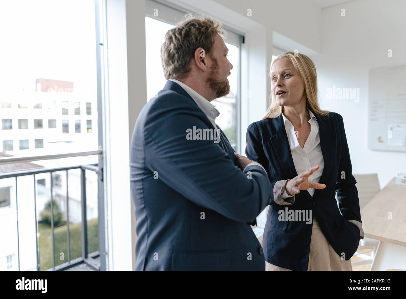 Businessman and businesswoman talking in office Stock Photo