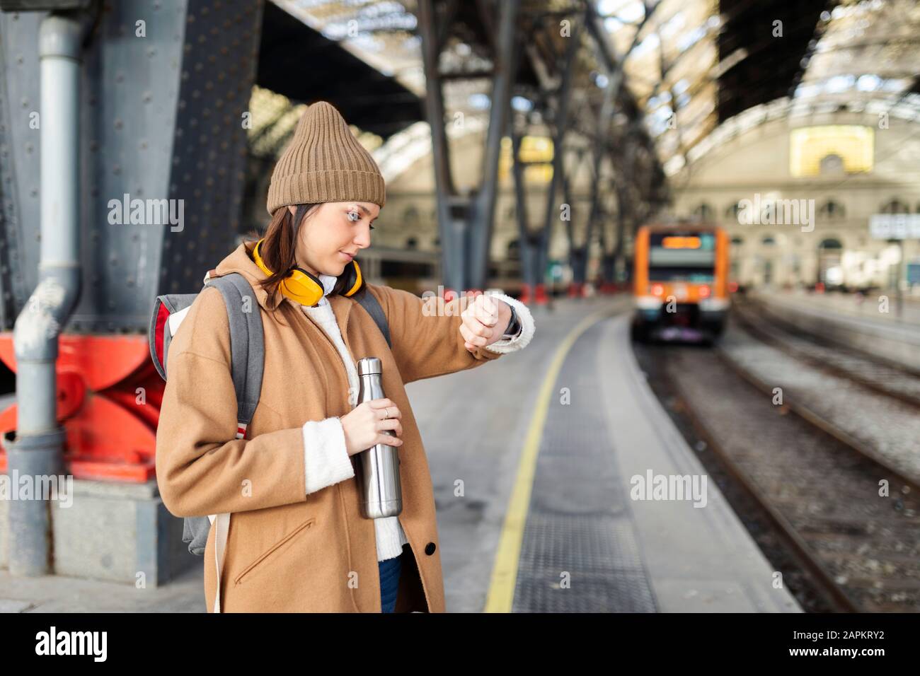 Young woman checking the time at the train station Stock Photo - Alamy