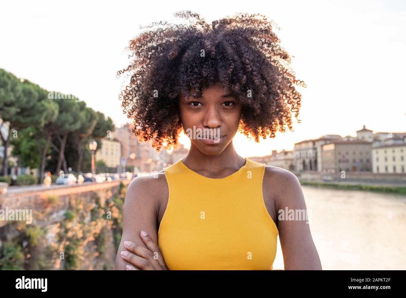 Portrait of a confident young woman at river Arno at sunset, Florence, Italy Stock Photo