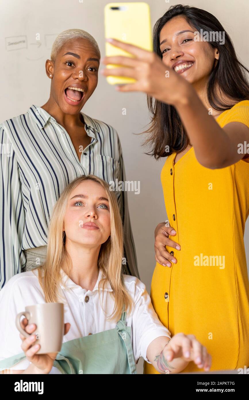 Happy businesswomen taking a selfie in office Stock Photo - Alamy