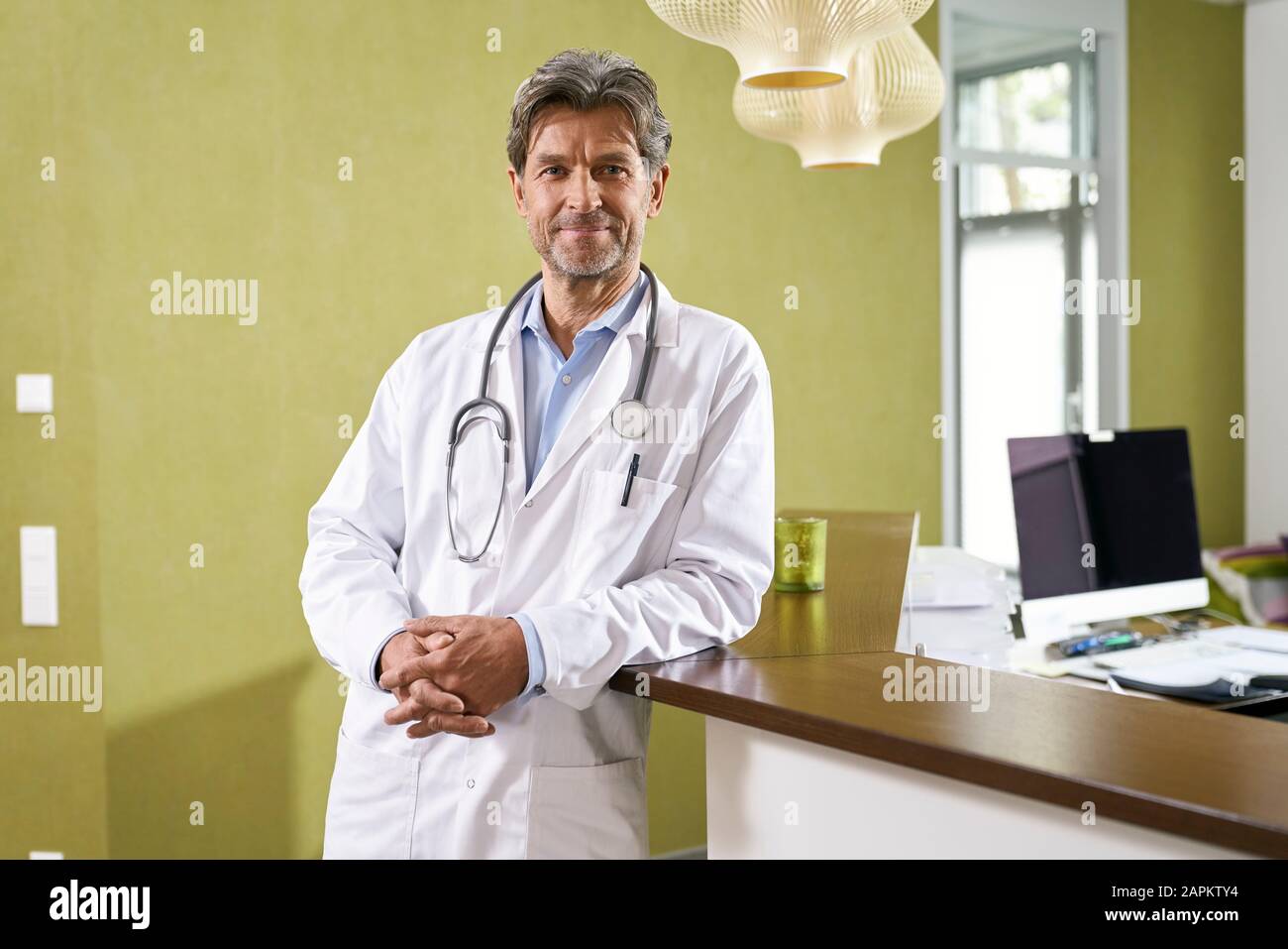 Portrait of confident doctor at reception in his medical practice Stock Photo