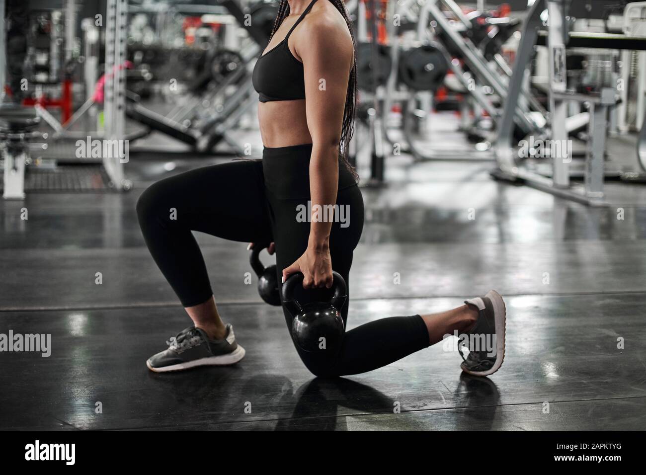 Female athlete doing lunges with kettlebells Stock Photo Alamy