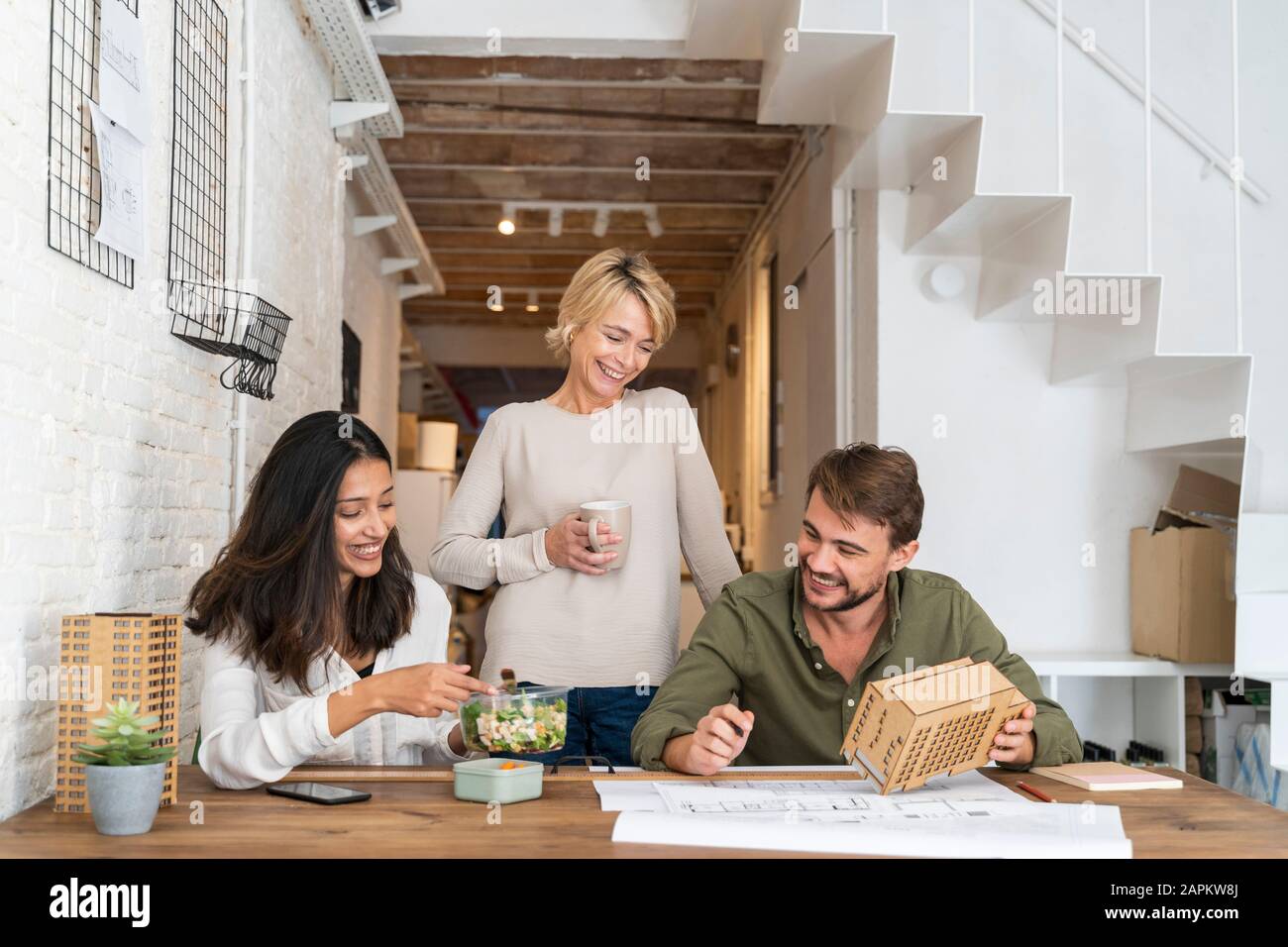 Three colleagues at desk in architect's office Stock Photo