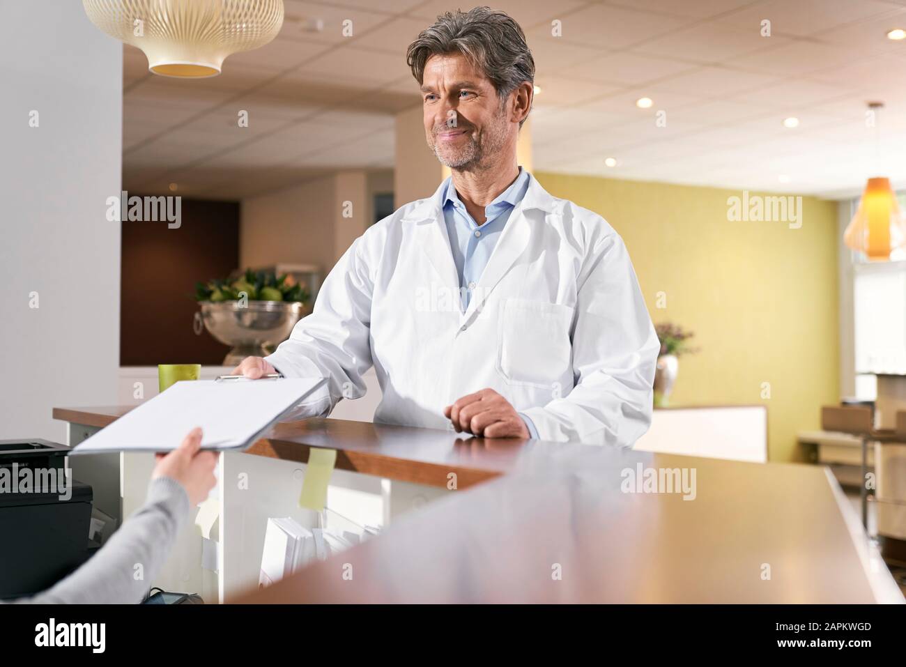 Doctor taking medical record at reception in his medical practice Stock Photo
