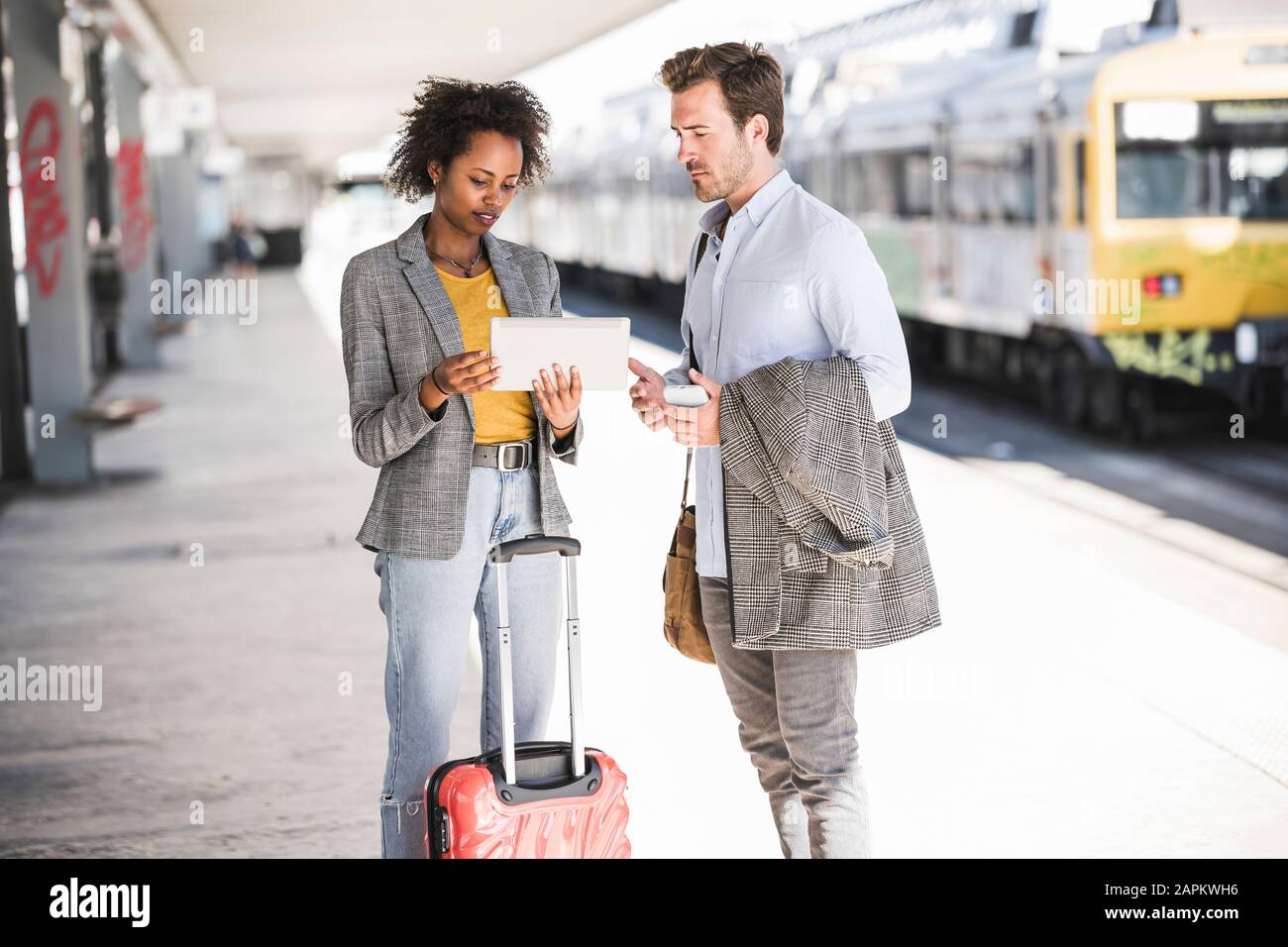 Young businessman and businesswoman using tablet together at the train station Stock Photo