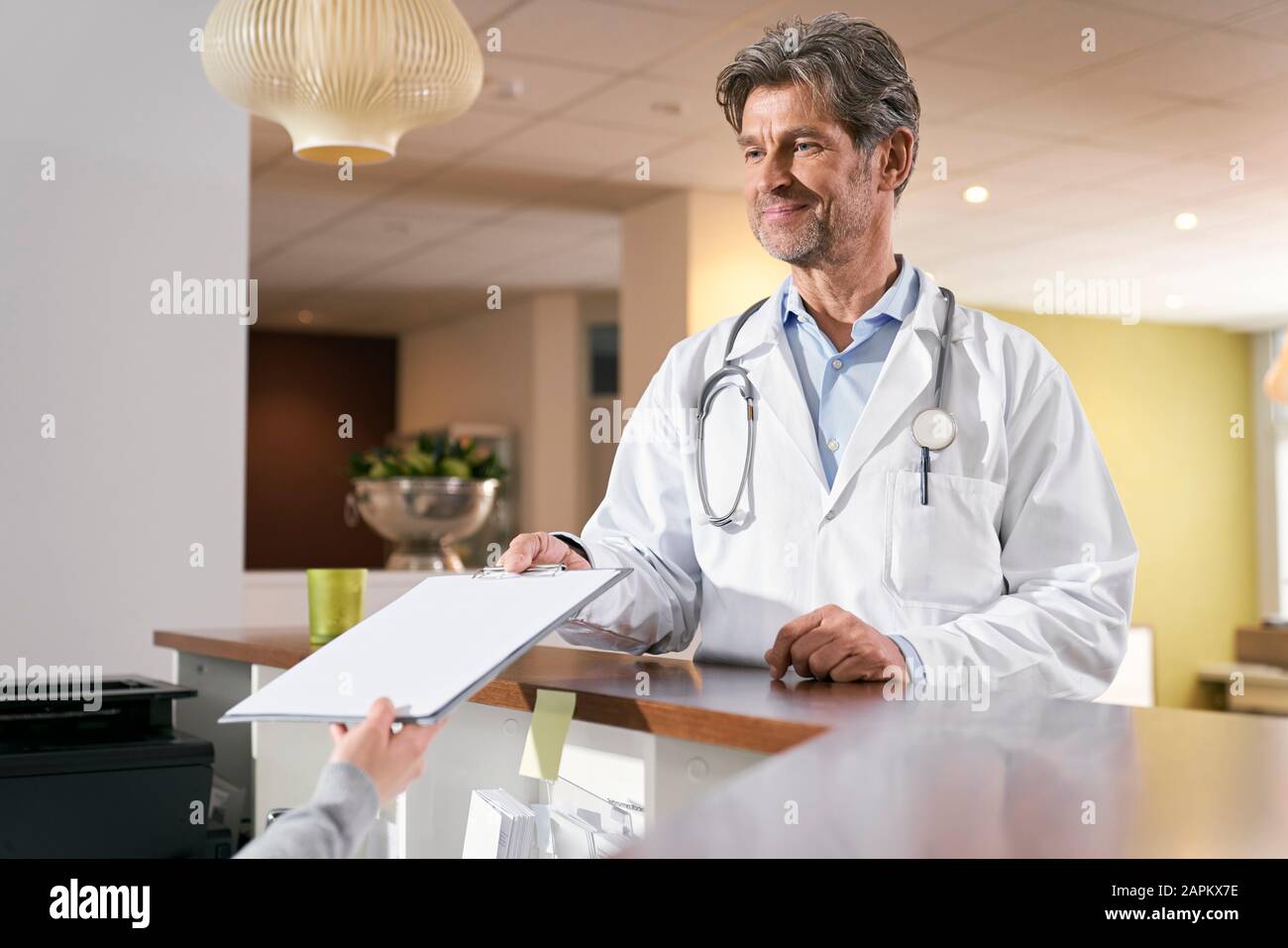 Doctor taking medical record at reception in his medical practice Stock Photo