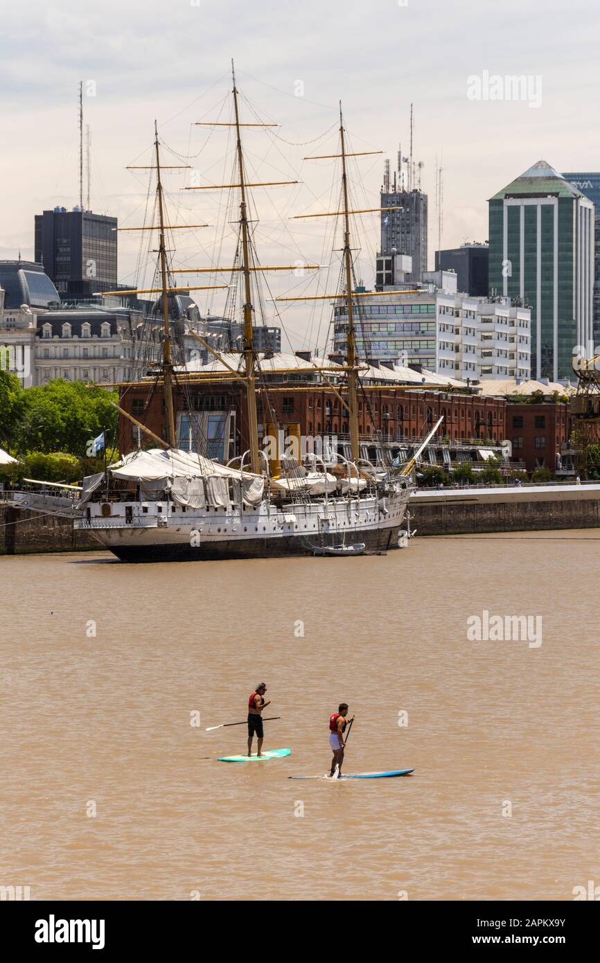 View to couple of men on Stand Up Paddle boards on river in Puerto Madero, Buenos Aires, Argentina Stock Photo