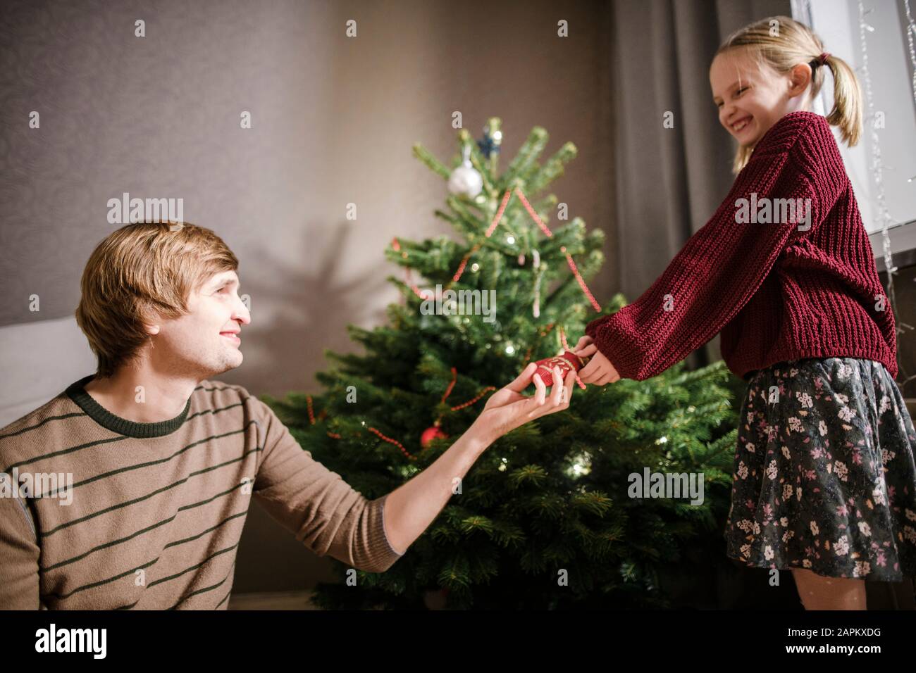 Blonde girl with her father decorating Christmas tree Stock Photo - Alamy