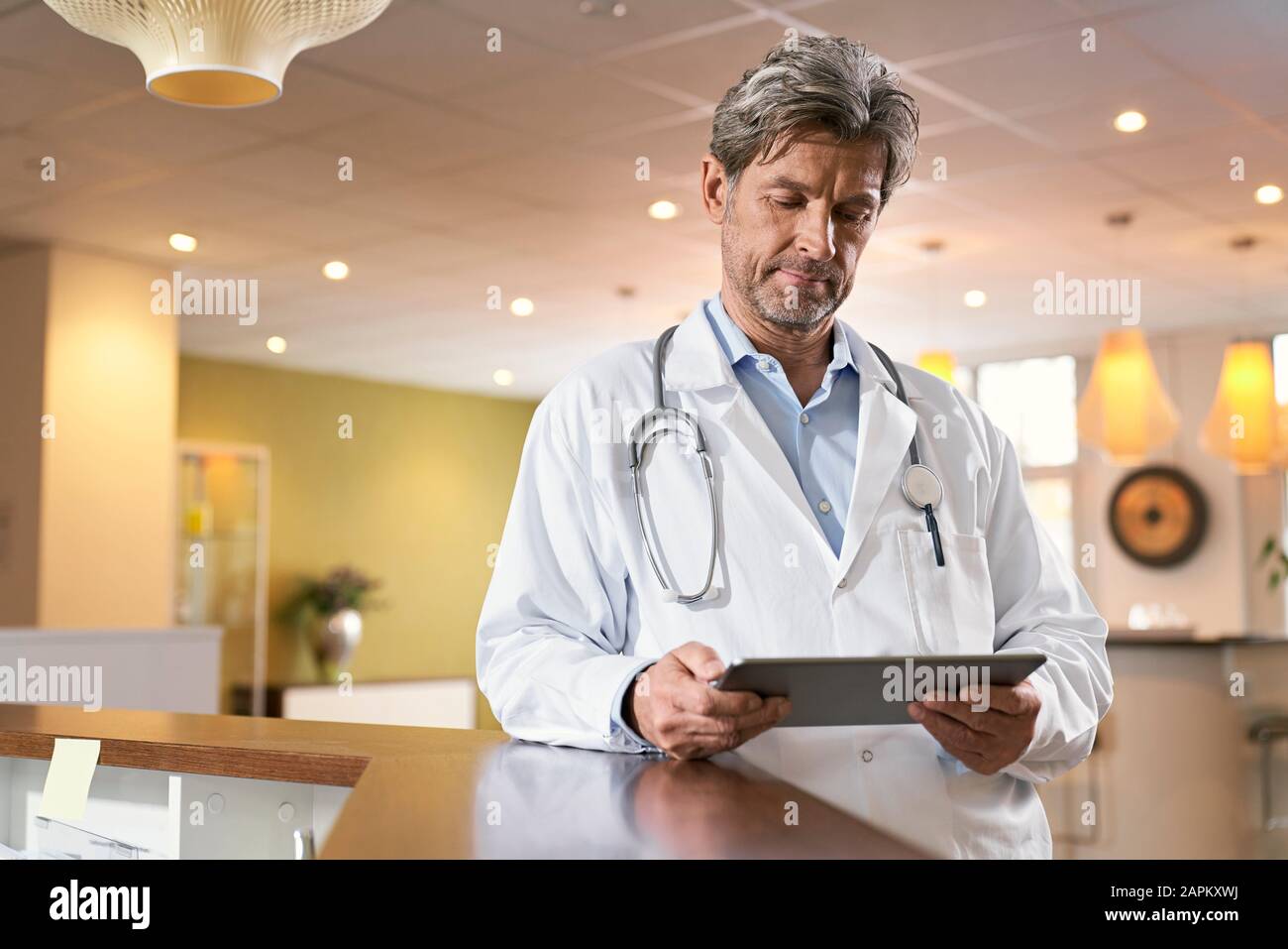 Doctor using tablet at reception in his medical practice Stock Photo