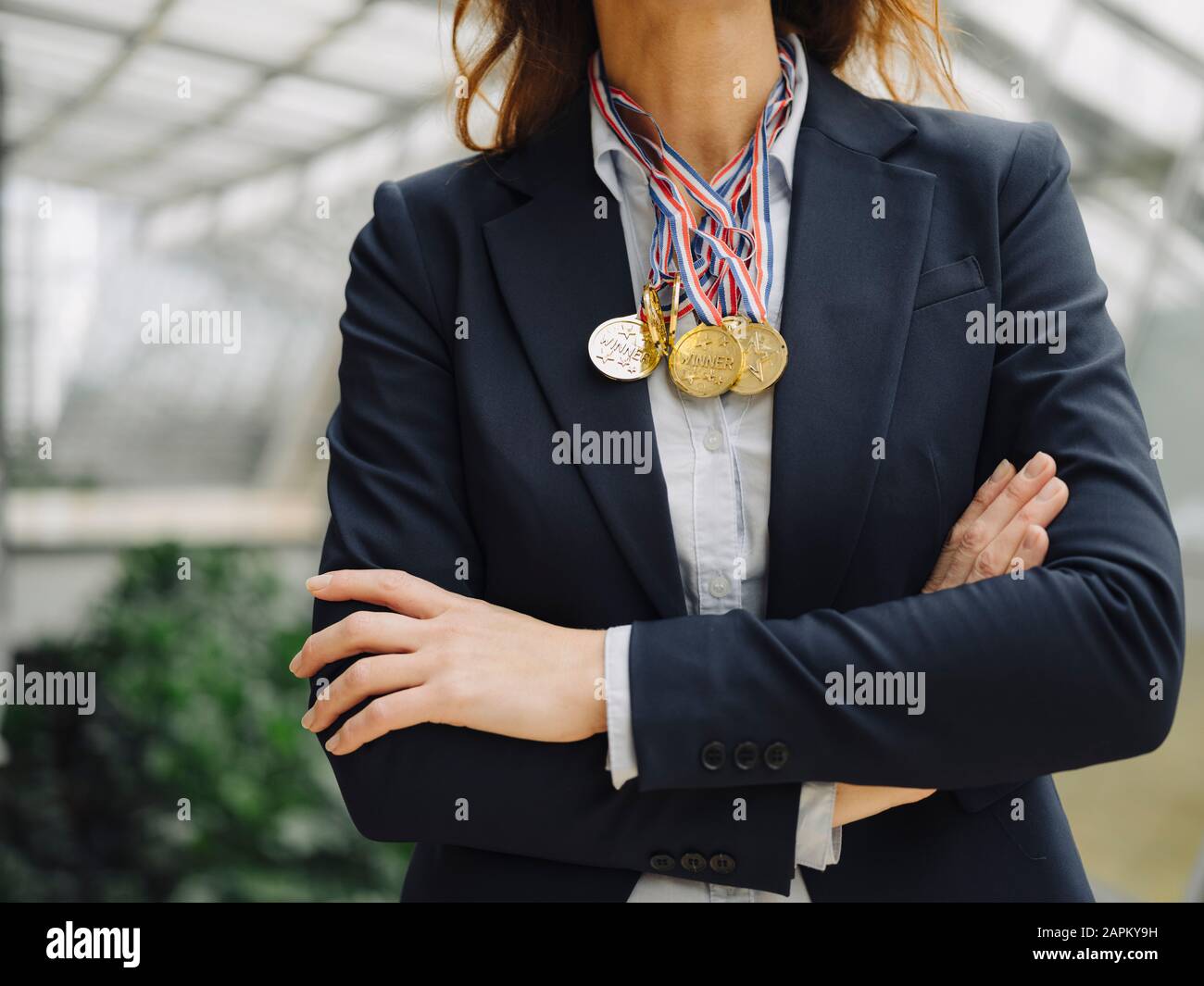 Close-up of businesswoman wearing medals around her neck in office Stock Photo