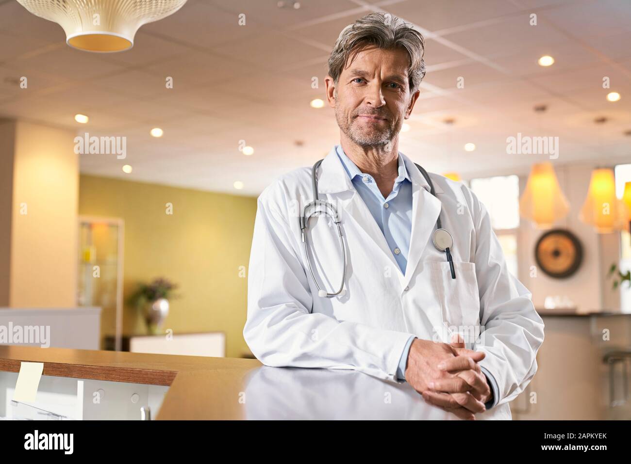 Portrait of confident doctor at reception in his medical practice Stock Photo