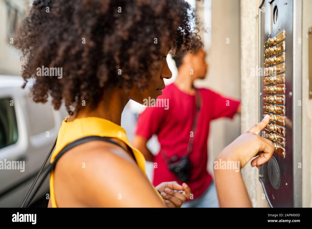 Young woman ringing the bell in the city Stock Photo