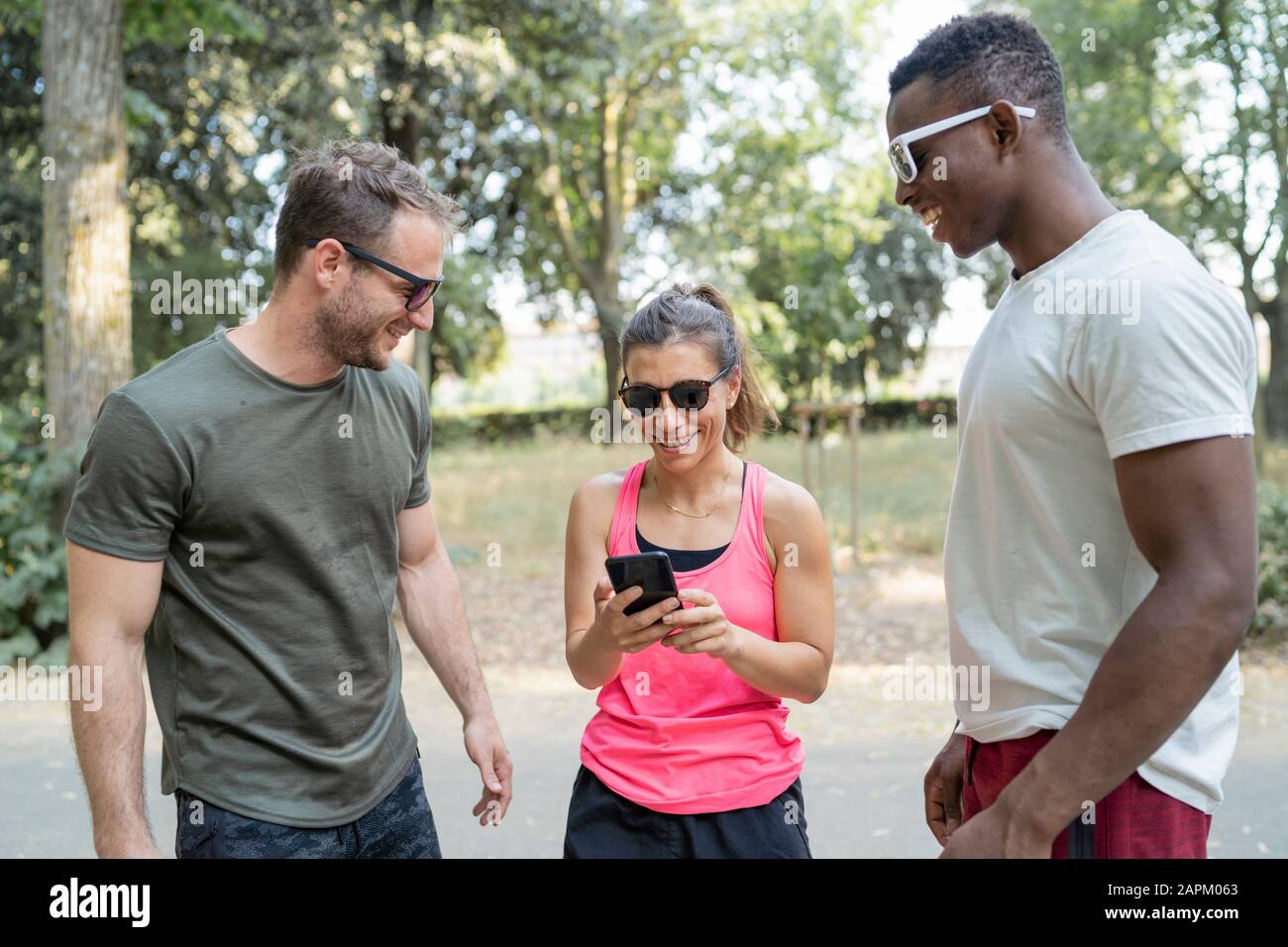 Friends having a break from exercising looking at smartphone Stock Photo