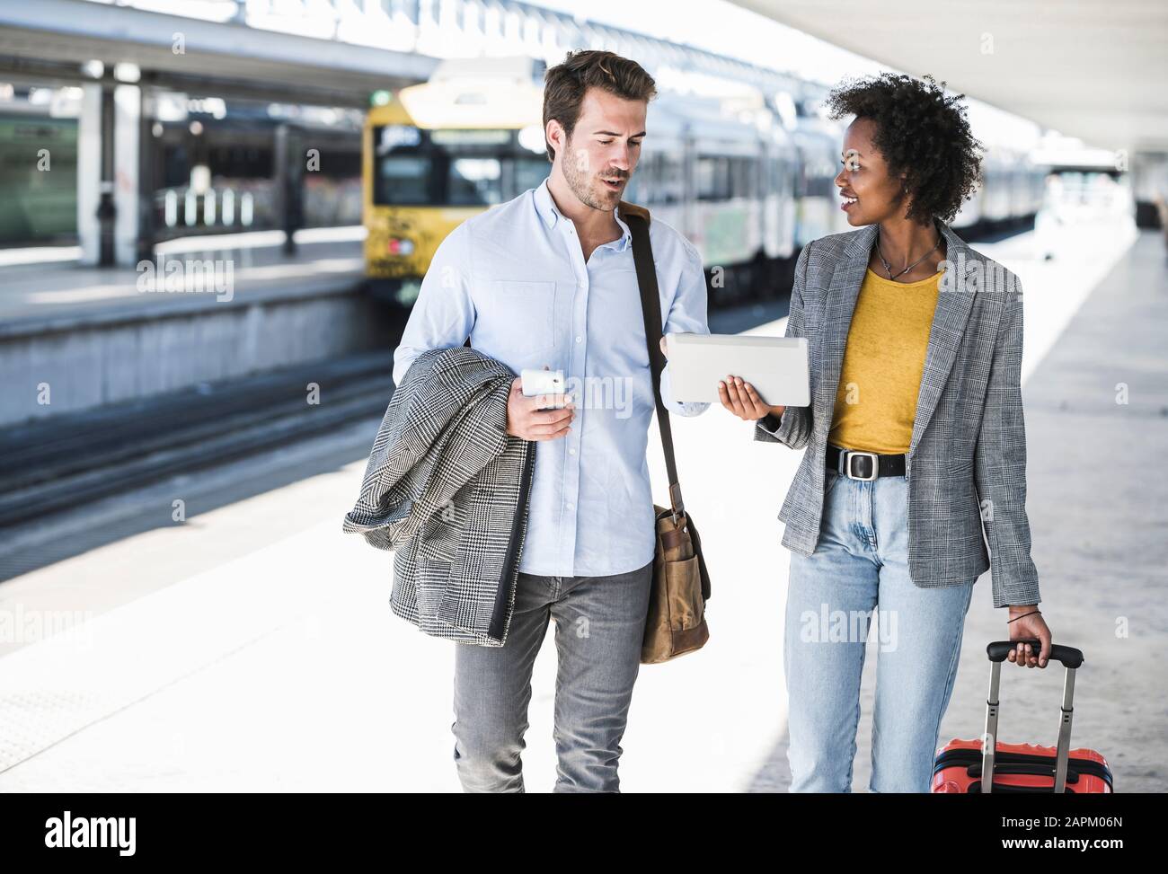 Young businessman and businesswoman using tablet together at the train station Stock Photo