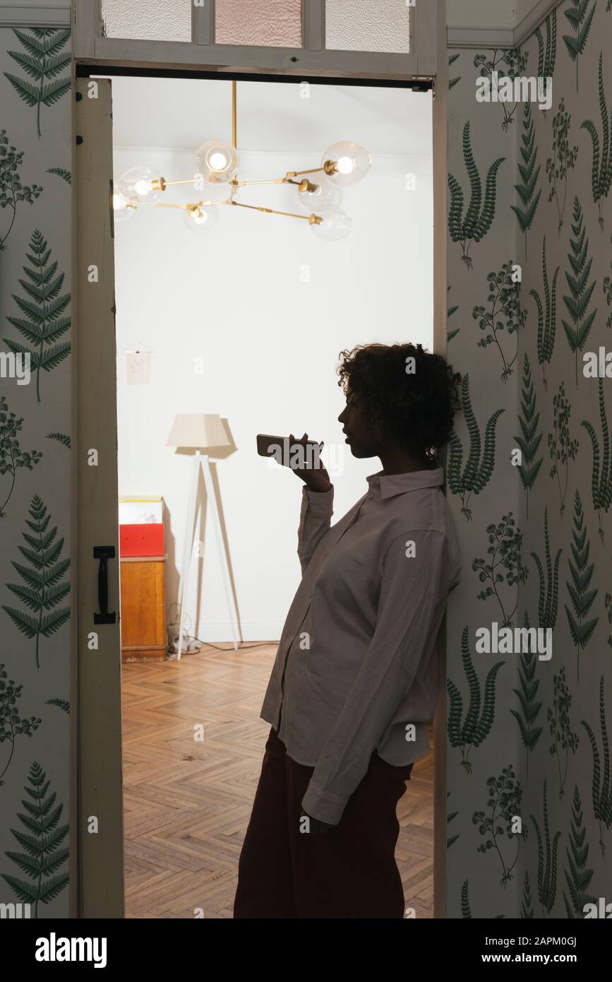 Young woman using smartphone at home Stock Photo