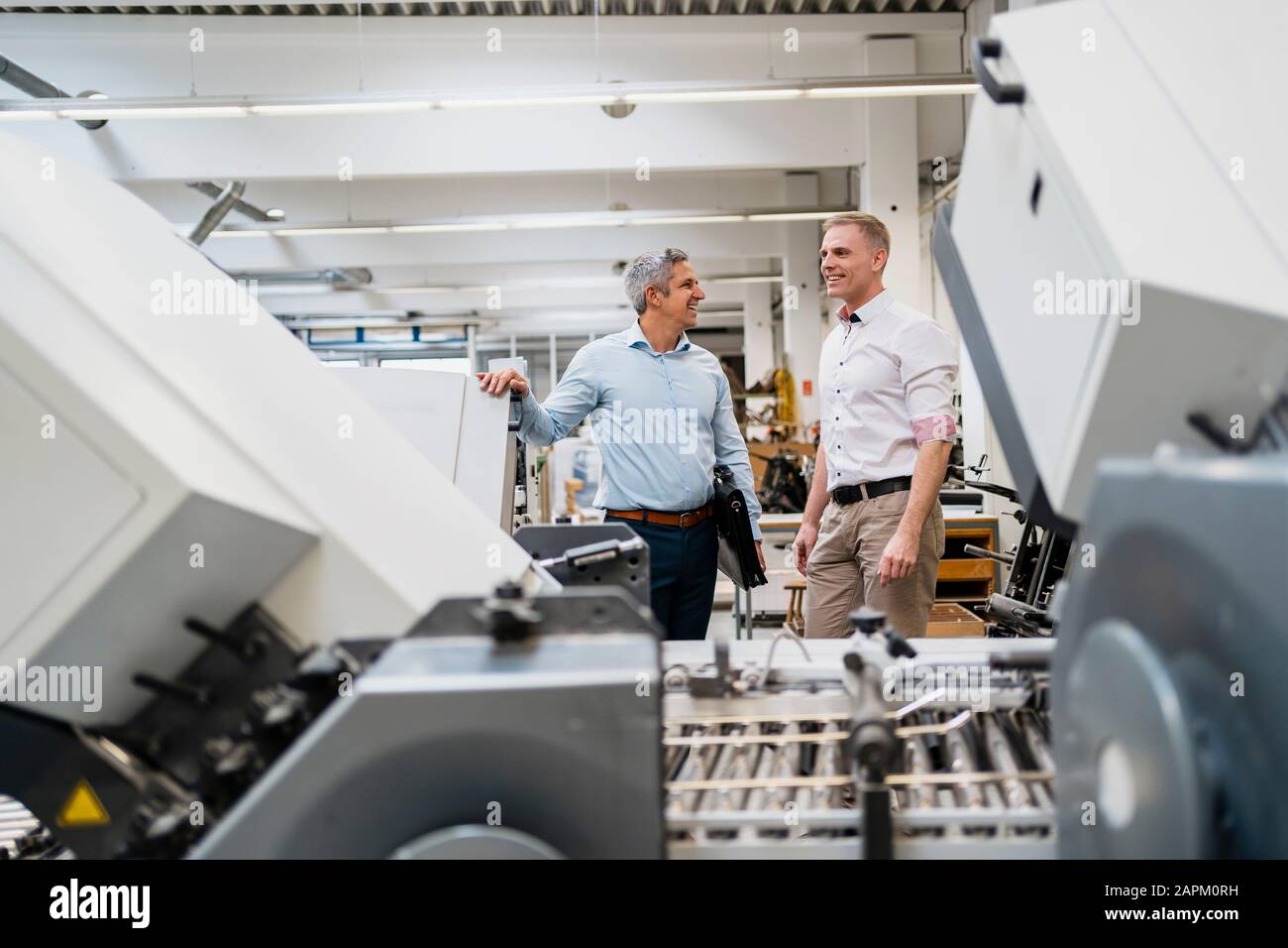 Two smiling colleagues in a factory Stock Photo - Alamy