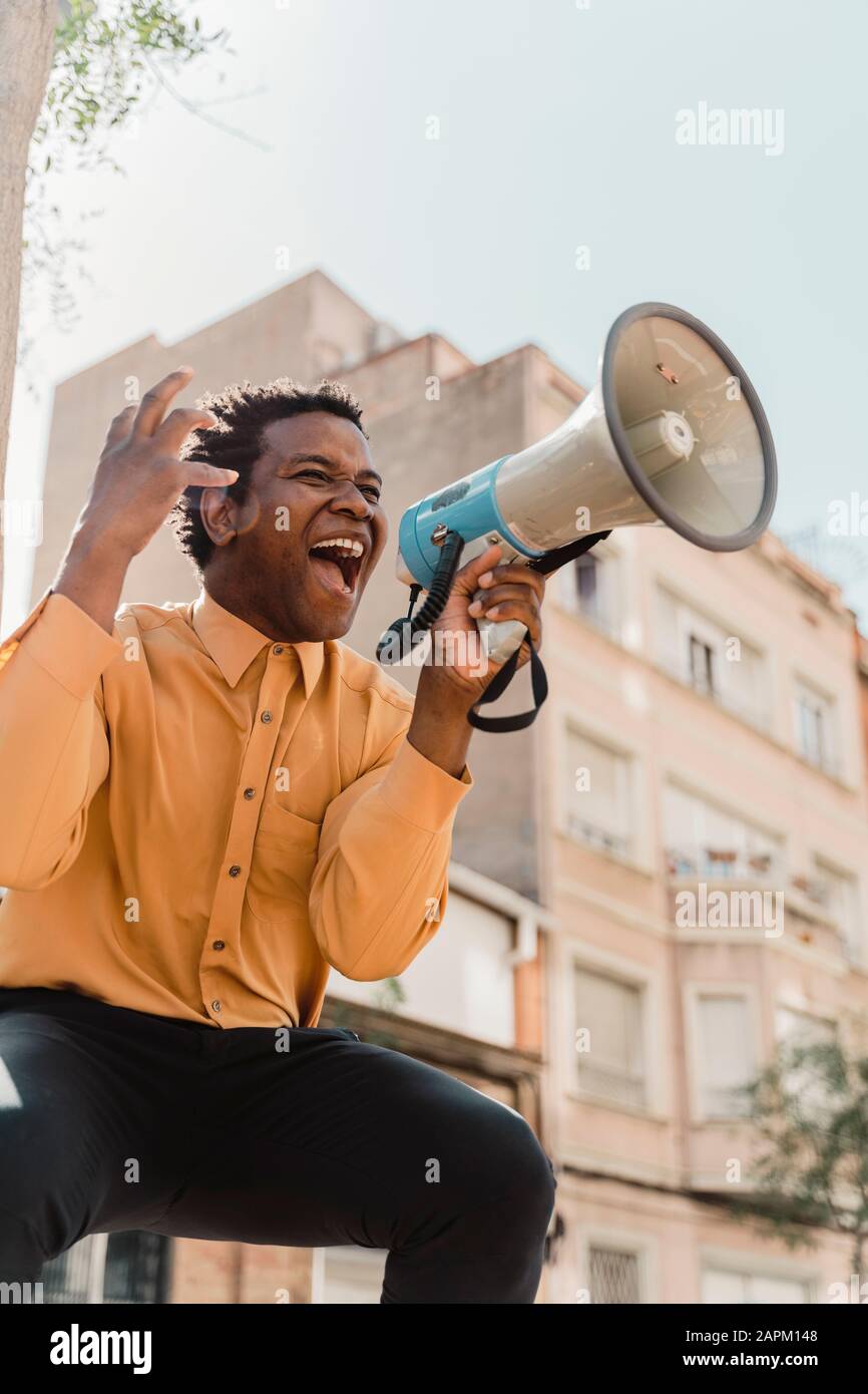 Mature man using megaphone and screaming Stock Photo