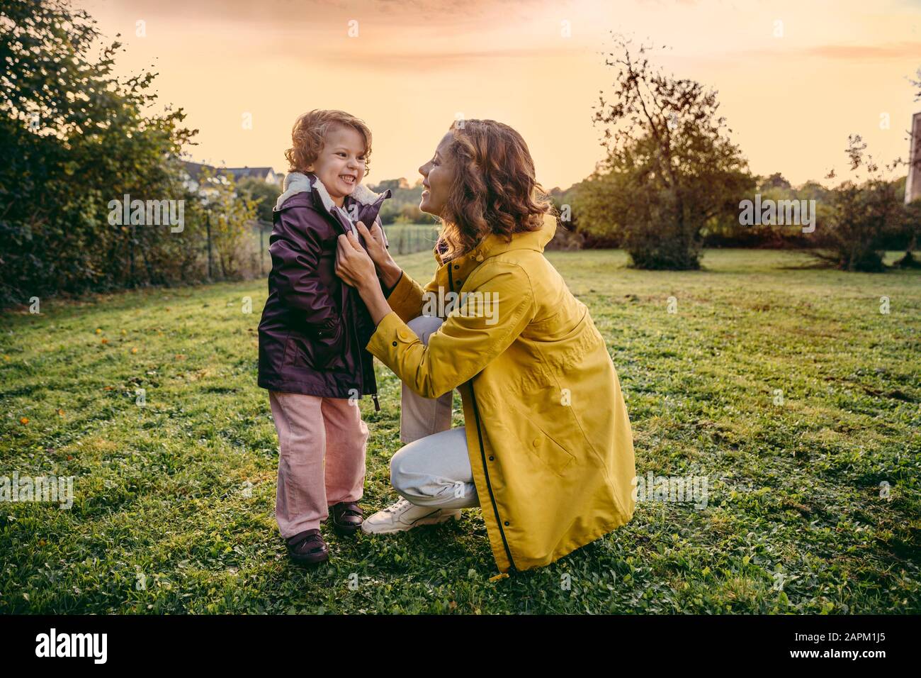 Happy mother with daughter on a meadow in autumn Stock Photo
