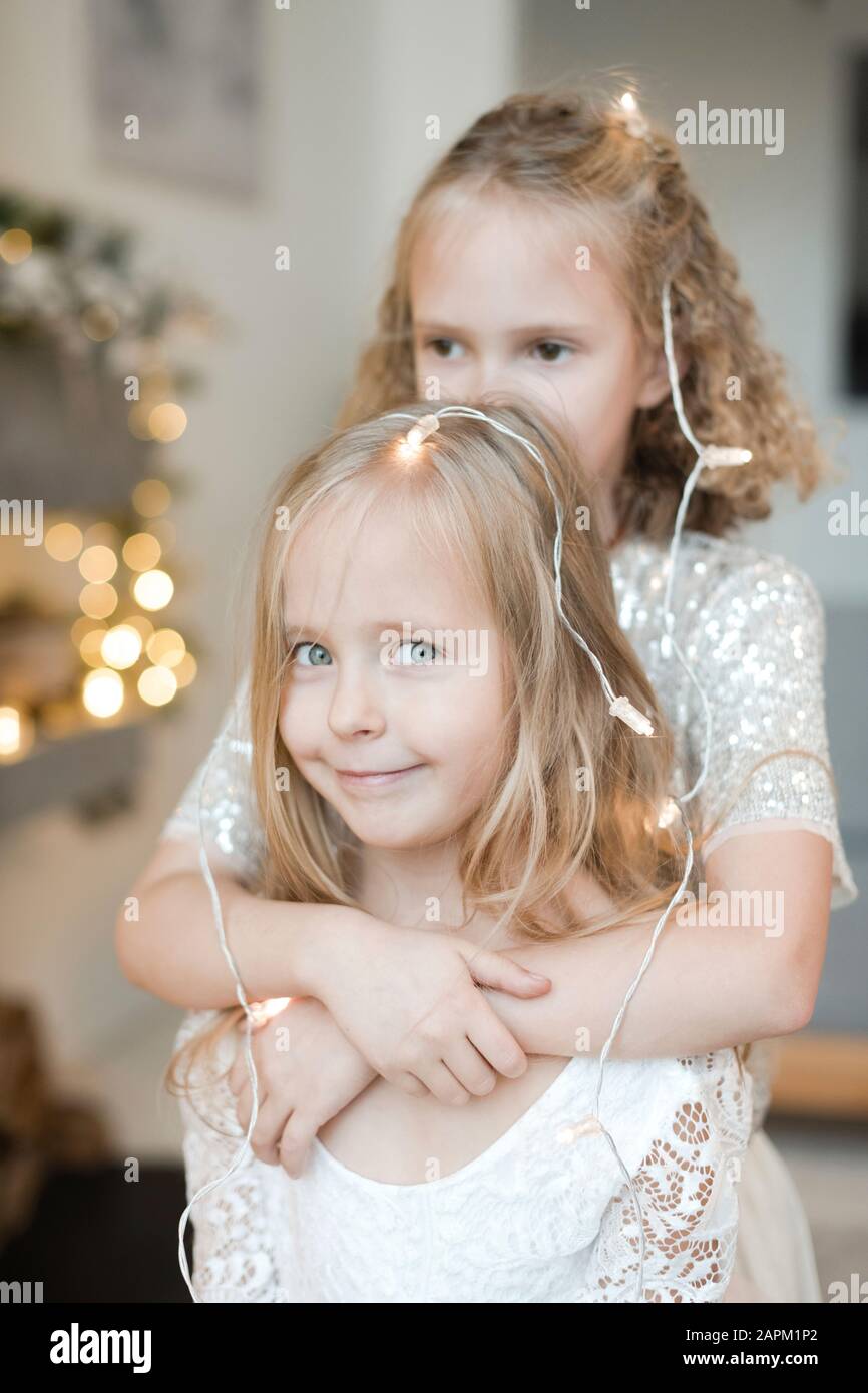 Portrair of little blond girl decorated with fairy lights Stock Photo