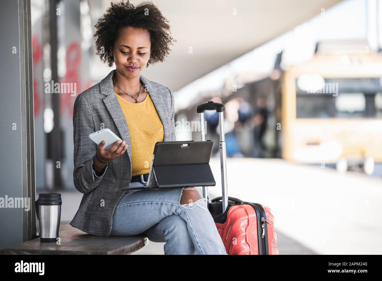 Young businesswoman using tablet and smartphone at the train station Stock Photo
