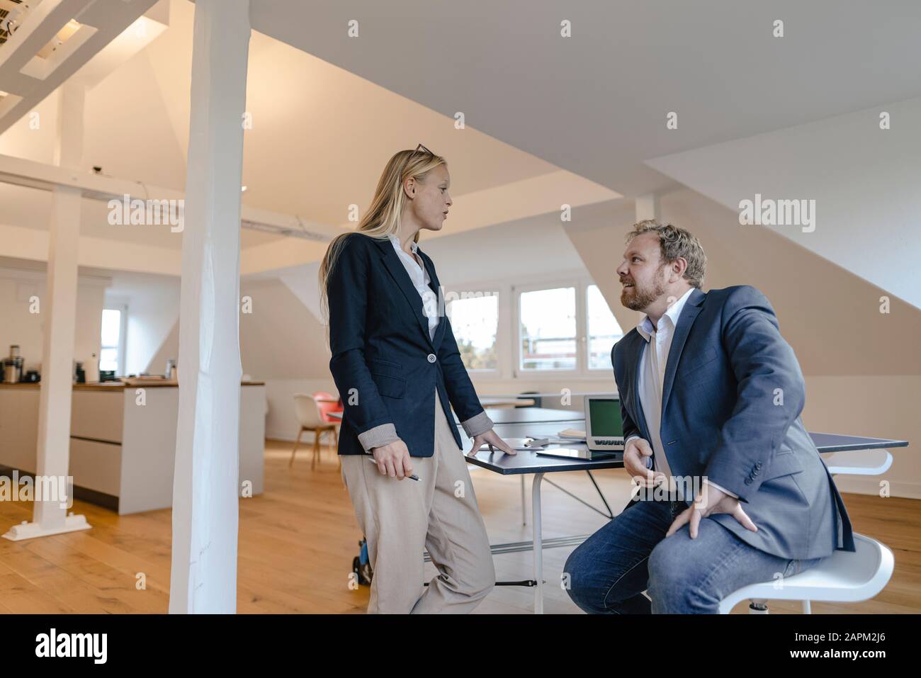 Businessman and businesswoman talking at table tennis table in office Stock Photo