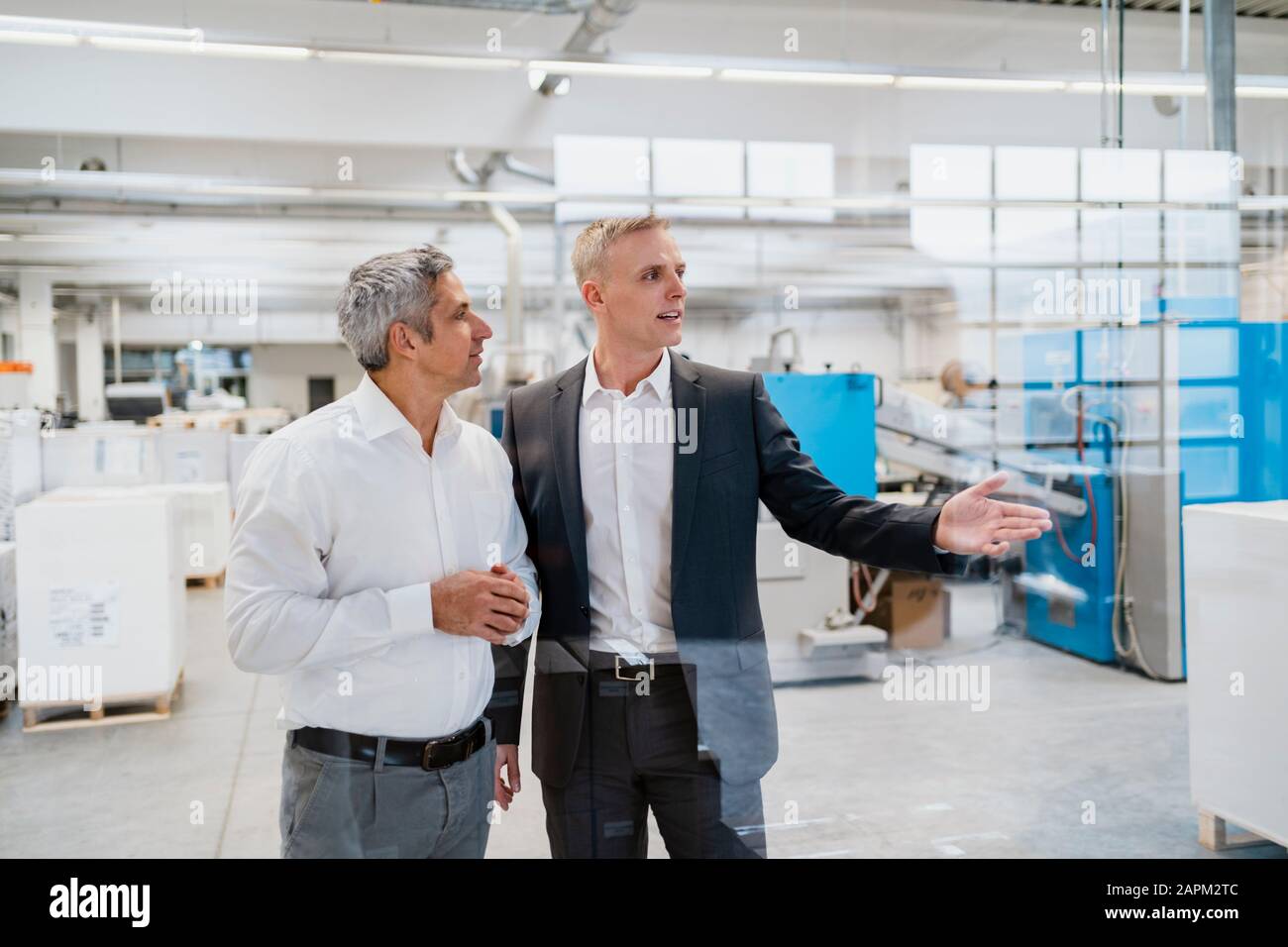 Two businessmen talking in a factory Stock Photo - Alamy