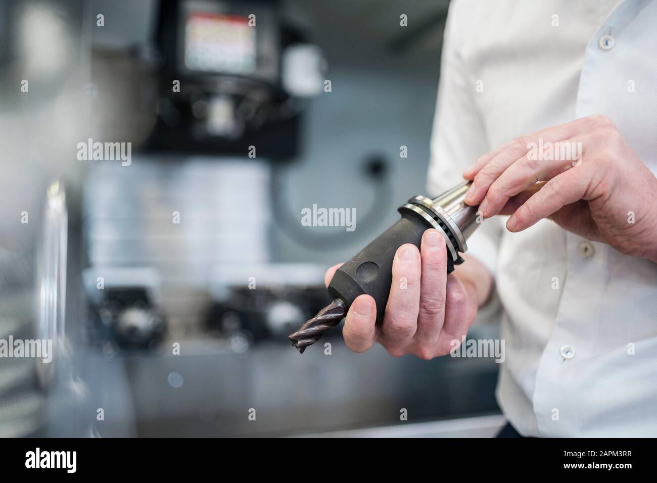 Close-up of man holding drillhead in a factory Stock Photo