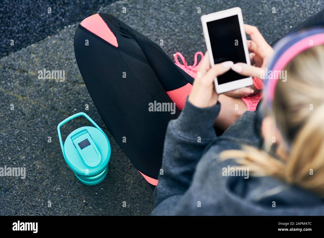 Young woman using smartphone after workout, elevated view Stock Photo