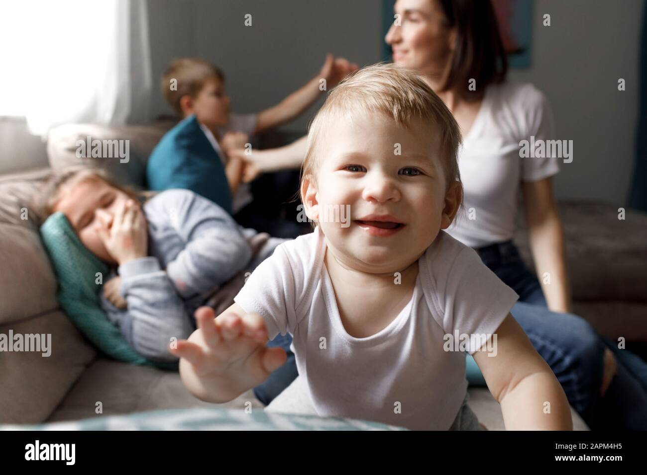 Portrait of happy baby boy with his family on couch in living room at