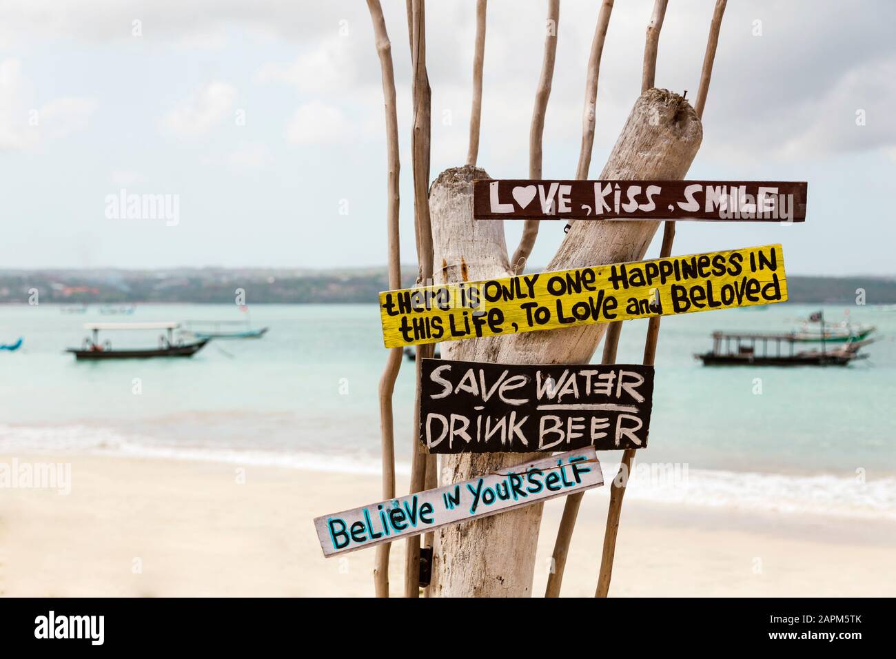 Indonesia, Bali, Jimbaran, Sign with motivational quotes standing on coastal beach Stock Photo