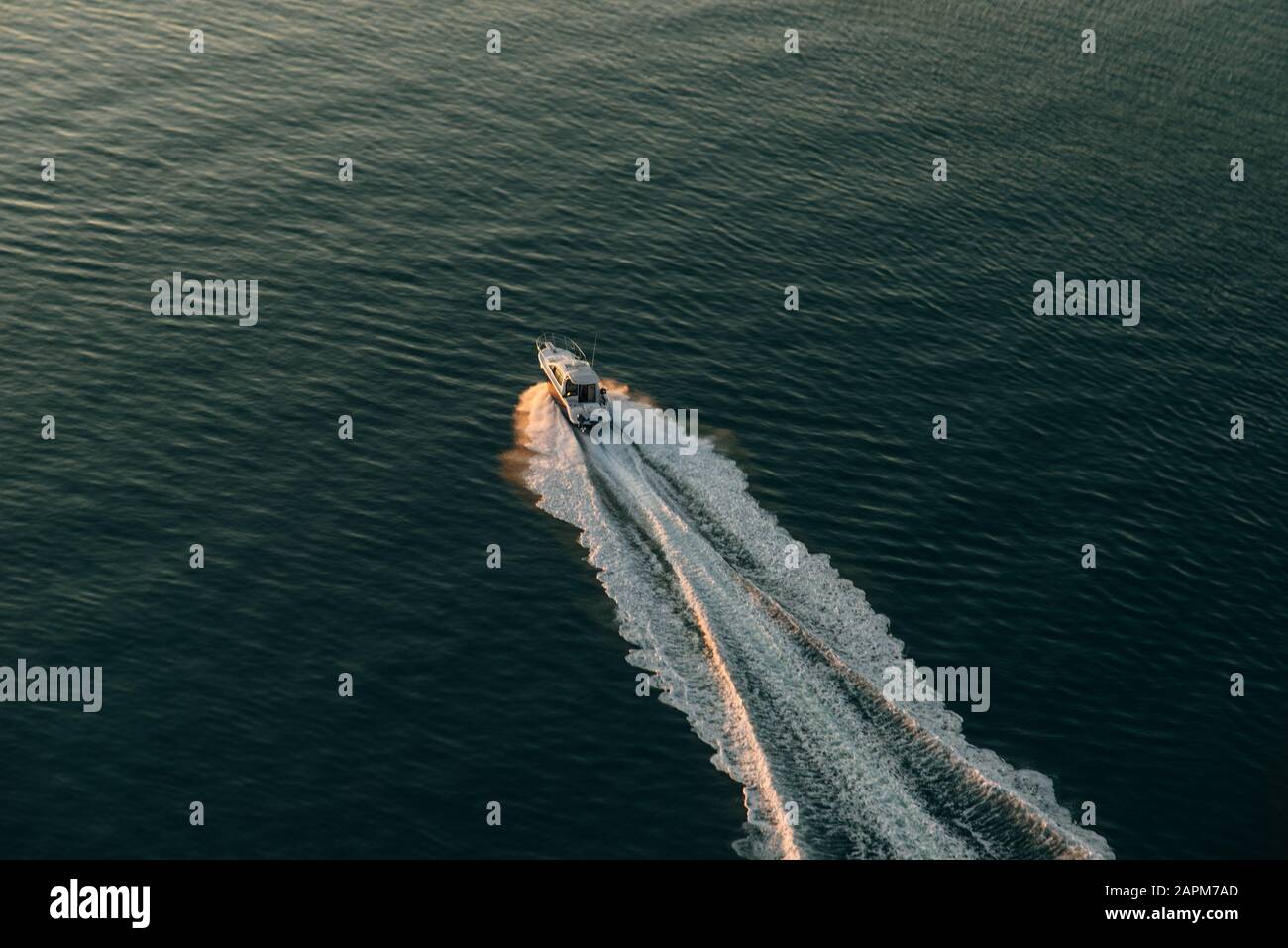 Aerial view of the boat in clear blue water at sunset in summer ...