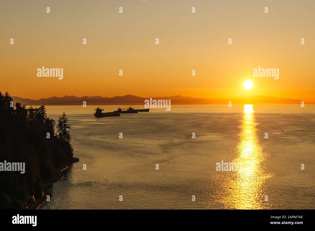 Golden Sunset into the sea with the silhouette of ship Stock Photo - Alamy