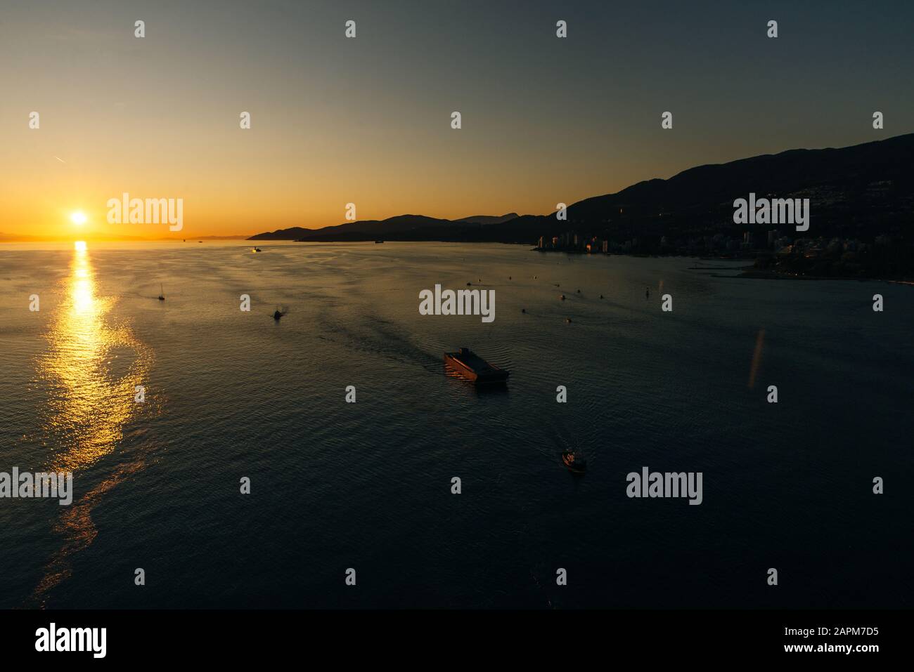 Golden Sunset into the sea with the silhouette of ship Stock Photo - Alamy