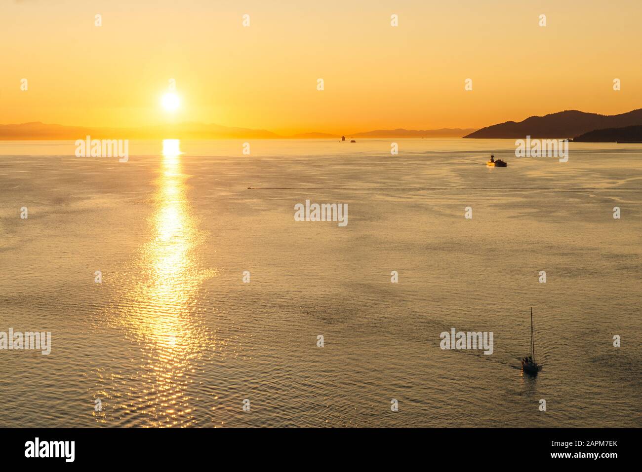 Golden Sunset into the sea with the silhouette of ship Stock Photo - Alamy