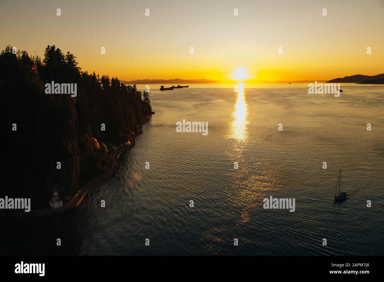 Golden Sunset into the sea with the silhouette of ship Stock Photo - Alamy