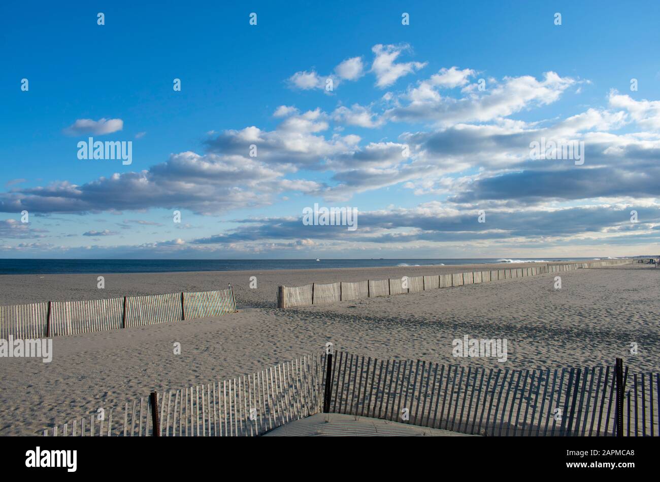 Heavy surf crashing into a sandy shoreline at Belmar Beach, New Jersey, USA, under a partly cloudy sky -01 Stock Photo