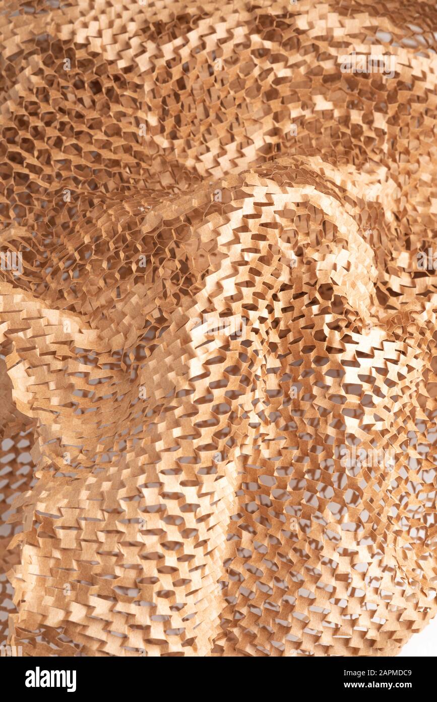 A closeup shot of a spread out brown kraft packaging paper filler set on white background Stock