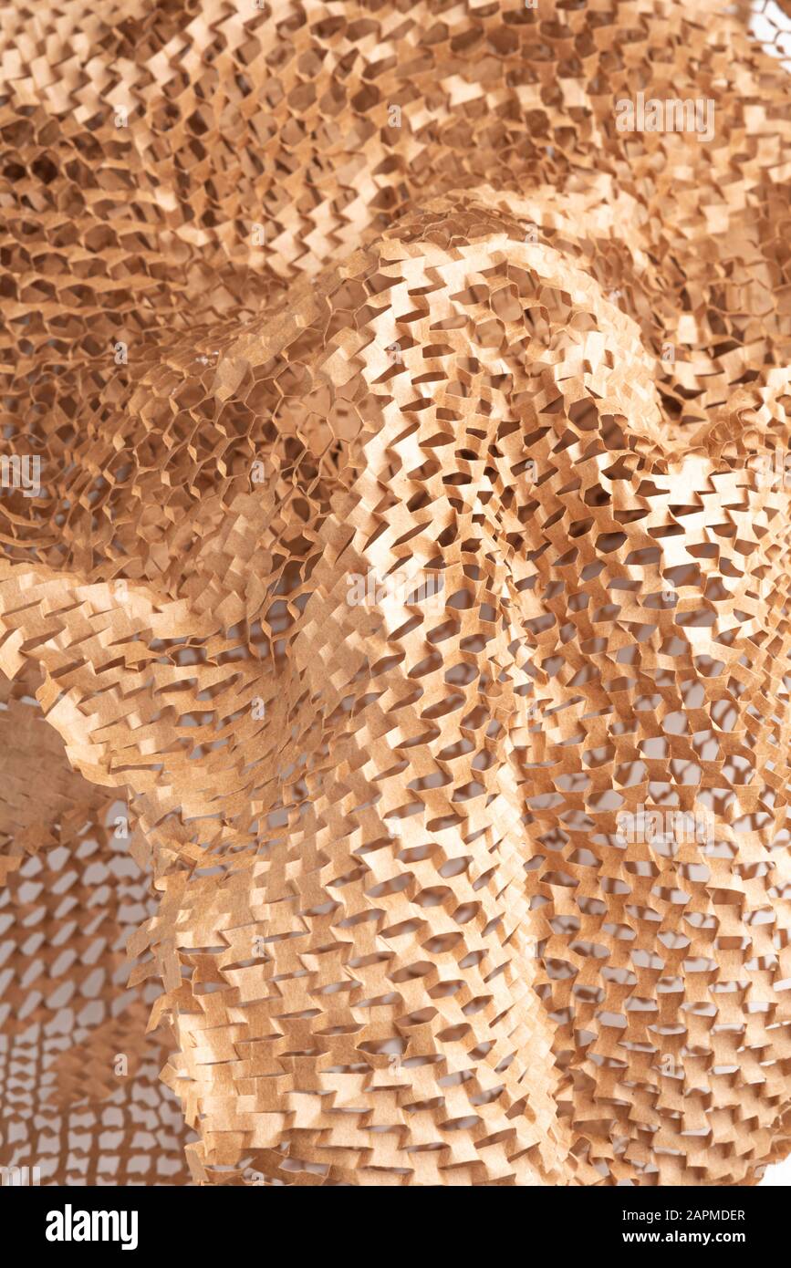 A closeup shot of a spread out brown kraft packaging paper filler set on white background Stock