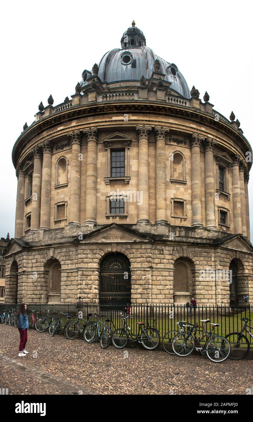 Radcliffe Camera Oxford, England on a rainy day. Student bicycles are chained  & parked against the spiked fence. Main reading room, Bodleian Library. Stock Photo