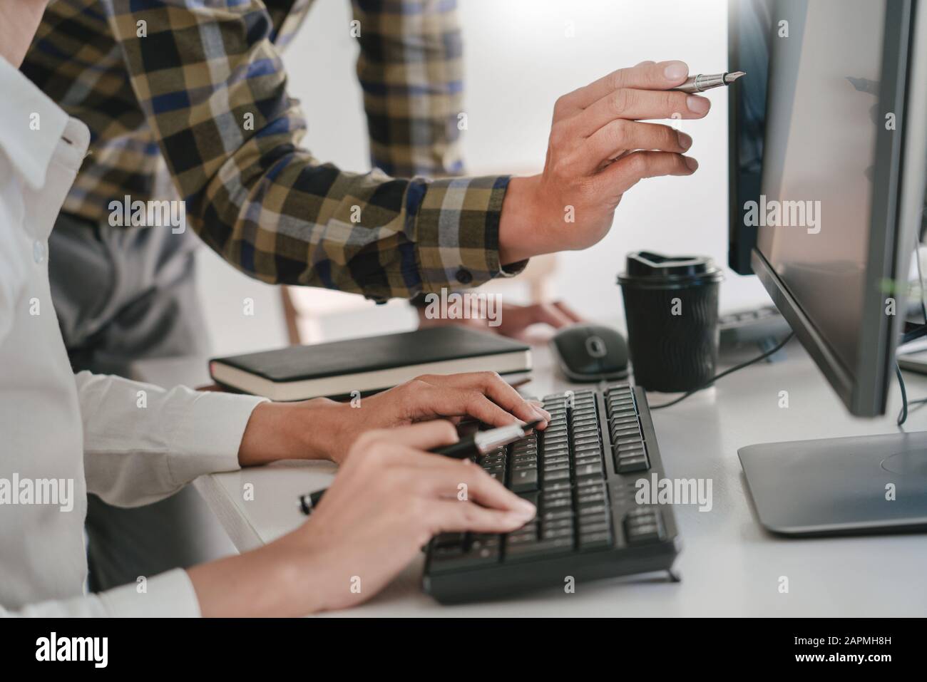 Young startup Programmers Sitting At Desks Working On Computers screen for Developing programming and coding to find solution to problem on New Applic Stock Photo