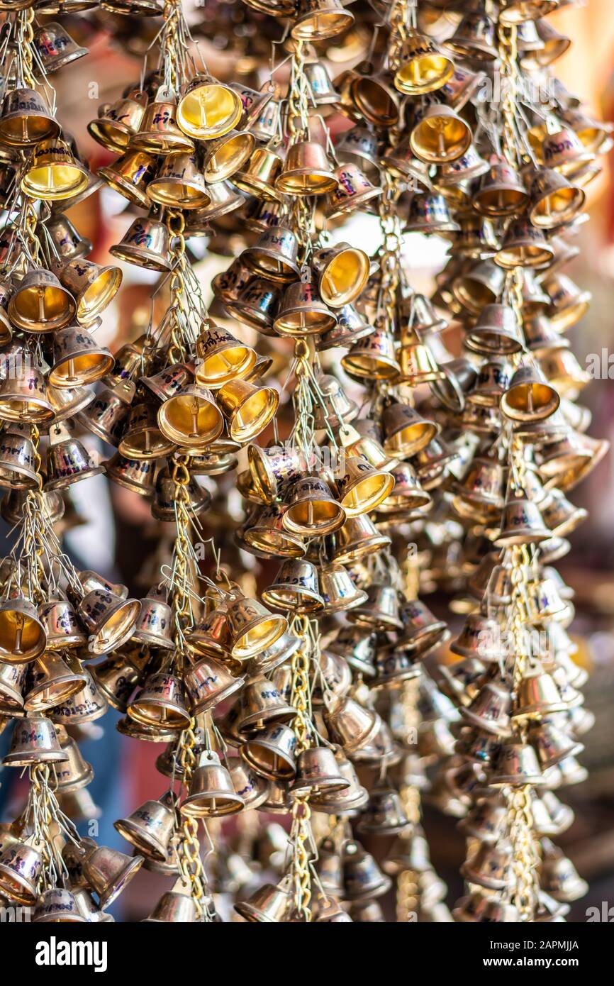 Many small gold bells hanging on chain in Buddhist temple. Ang Thong, Thailand, Feb 16, 2019 Stock Photo